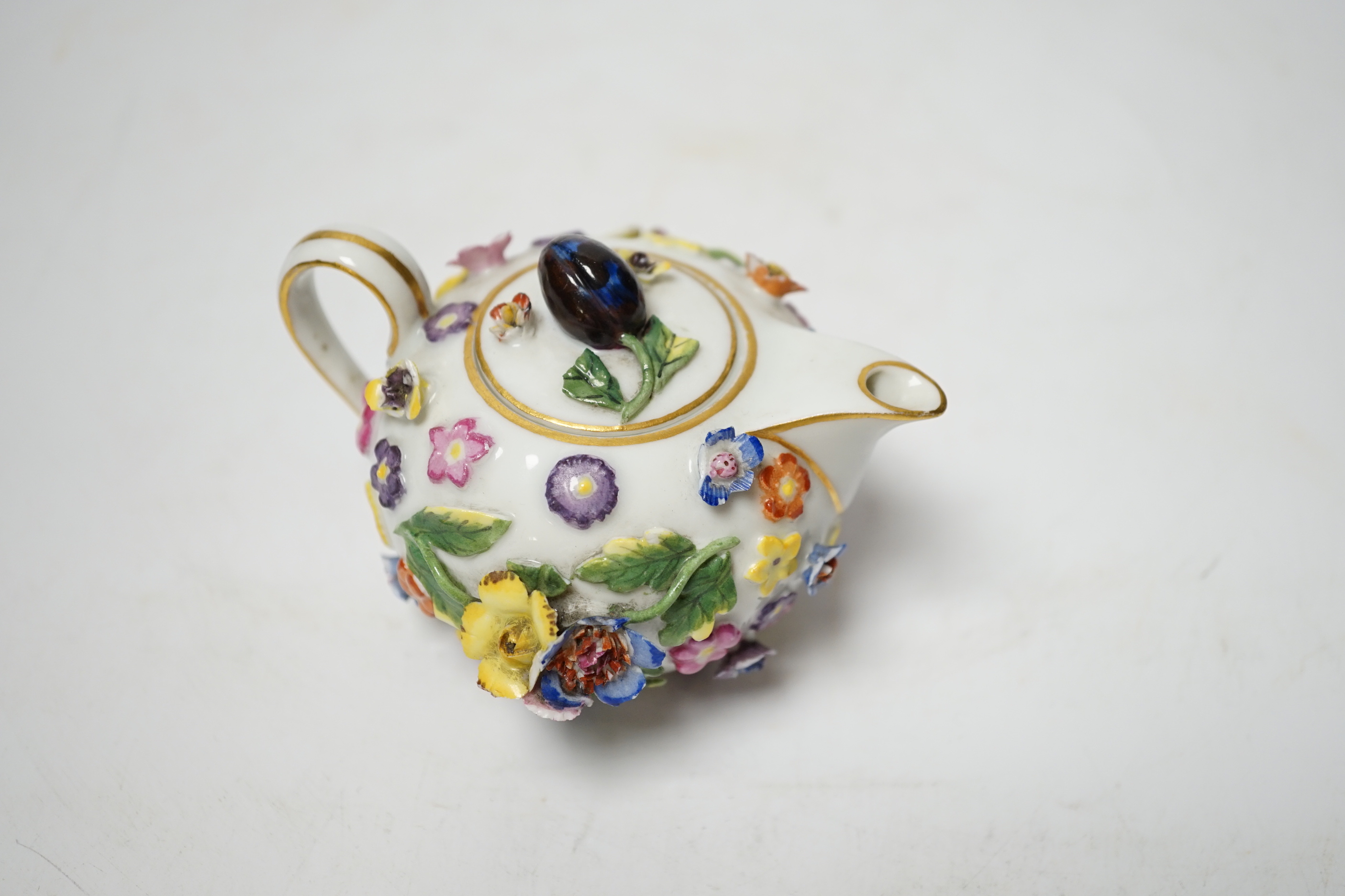 A miniature Meissen floral encrusted teapot, 7cm